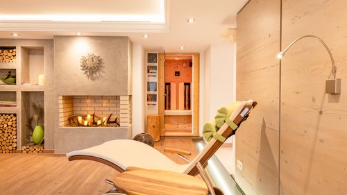 Deine Ferienwohnung in Neustift ✓ Entspannungsraum mit Liegestuhl, Kamin und Sauna im Hintergrund