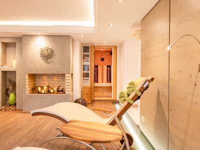 Deine Ferienwohnung in Neustift ✓ Entspannungsraum mit Liegestuhl, Kamin und Sauna im Hintergrund