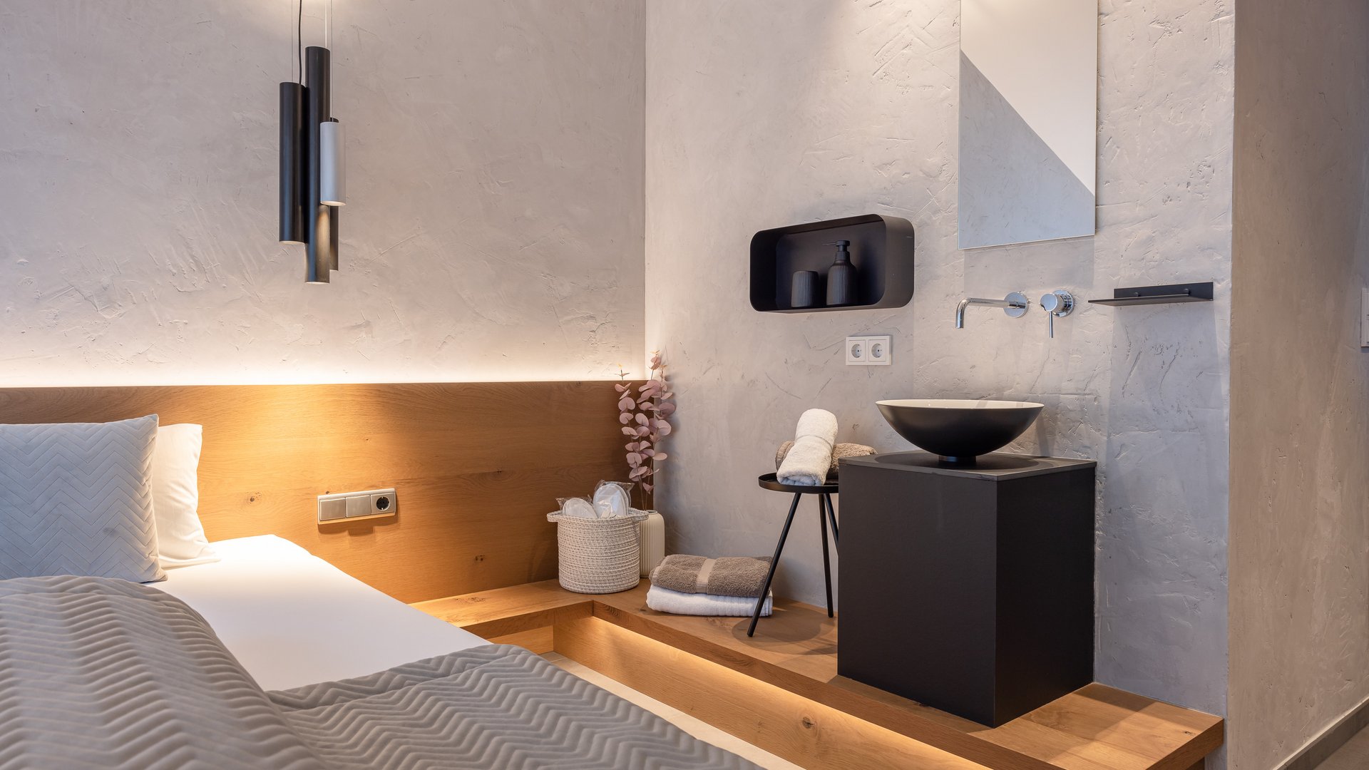 Deine Ferienwohnung in Neustift ✓ Modernes Schlafzimmer mit integriertem Waschbecken und stilvoller Beleuchtung