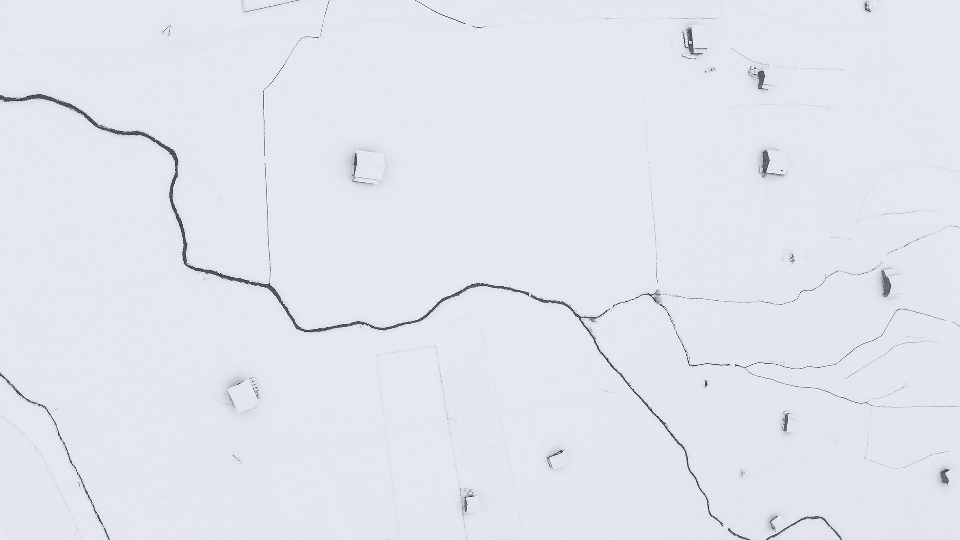 Deine Ferienwohnung in Neustift ✓ Luftaufnahme von schneebedecktem Land mit verstreuten Häusern und dunklen Wegen
